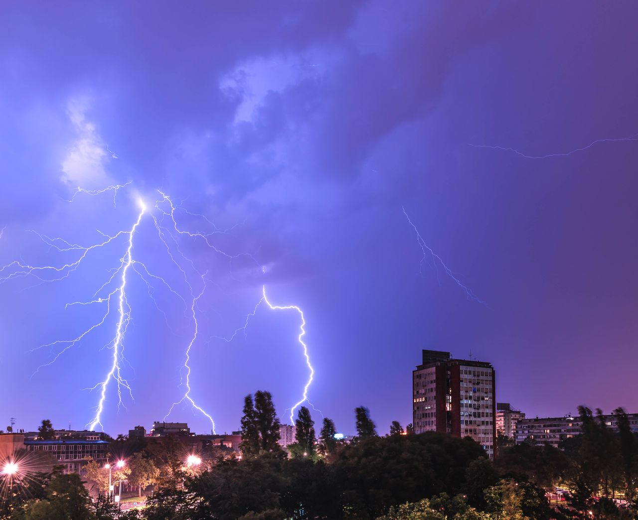 The Art of Drawing Readers In: Your attractive post title goes here Vivid lightning bolt striking during a nighttime thunderstorm over a city skyline, capturing the power of nature.